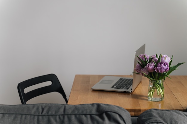 Local de trabalho em casa, escritório com flores de laptop e tulipas. 8 de março. primavera. vida lenta. atento