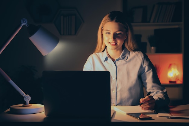 Local de trabalho em casa Mulher com caneta e notebook trabalhando no laptop na mesa branca na sala