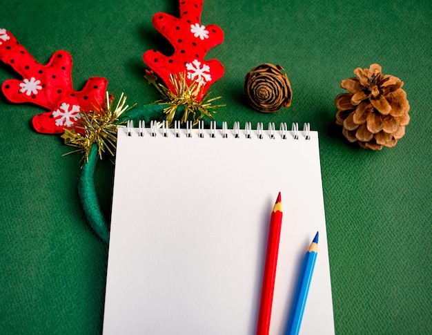 Local de trabalho para o conceito de Natal Caderno em branco e lápis de cor para o seu texto