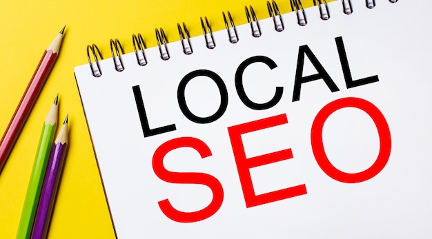 LOCAL SEO em um bloco de notas branco com lápis em um fundo amarelo. Conceito de negócios