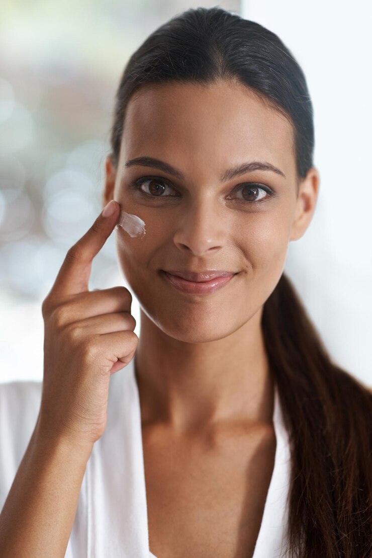 Foto loção feminina para o rosto e retrato para beleza sorriso com rotina de pele matinal e produto de cosméticos no banheiro creme protetor solar ou hidratante para o cuidado da pele facial ou máscara com brilho em casa