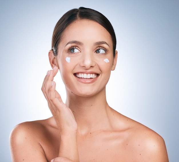 Loção mulher e sorriso em estúdio para creme de cuidados com a pele e hidratante em fundo azul produto de dermatologia e menina com felicidade para resultados rotina e cosméticos ou protetor solar para proteção