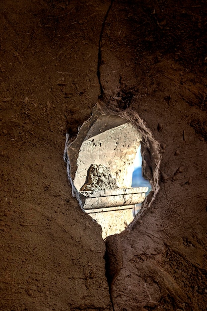 Loch in der Steinmauer eines Kirchenkonzepts der vergehenden Zeit