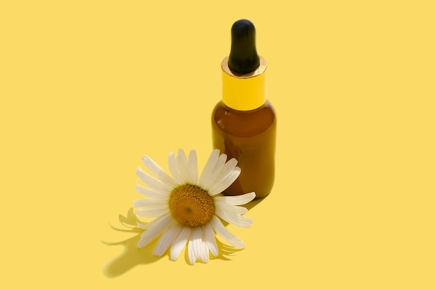 Loción cosmética natural con flores de manzanilla Sobre un fondo amarillo Lugar para el texto