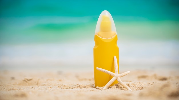 La loción de protección solar protege la piel de las mujeres en la playa tropical de verano al aire libre.