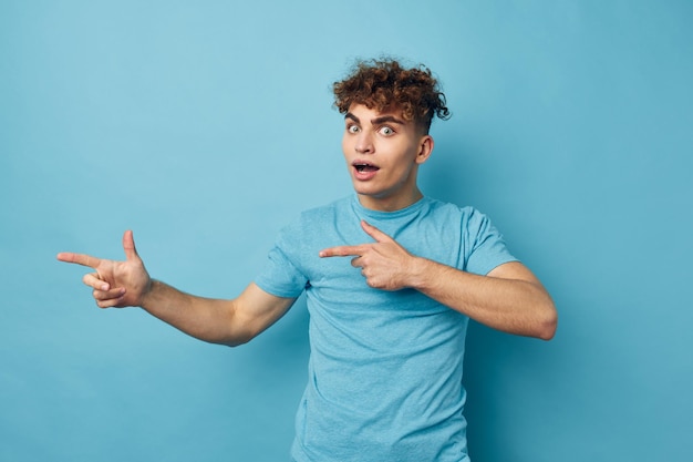 Lockiger Mann in einem T-Shirt auf einem farbigen Hintergrund posiert