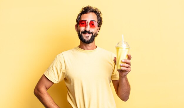 Loco expresivo sonriendo felizmente con una mano en la cadera y confiado