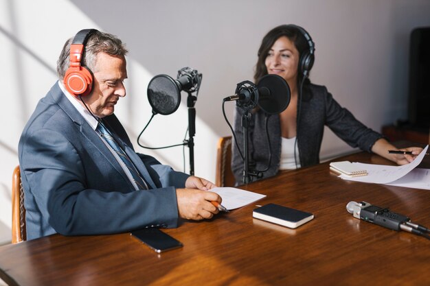 Locutor femenino entrevistando a su invitado en un estudio.