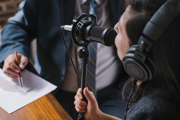 Locutor femenino entrevistando a su invitado en un estudio.