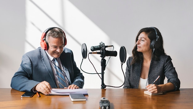 Locutor femenino entrevistando a su invitado en un estudio.