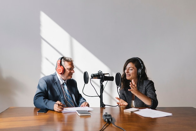 Locutor femenino entrevistando a su invitado en un estudio.