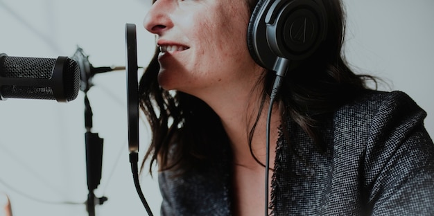 Foto locutor de radio femenino transmitiendo en vivo en un estudio.