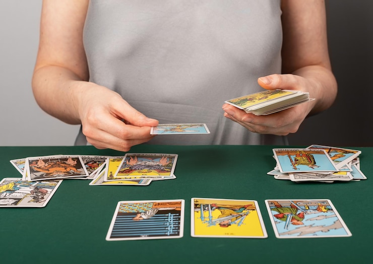 Foto lodz polonia 07 de abril de 2023 lector de tarot extendiendo naipes en el escritorio
