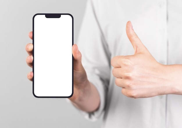 Lodz, Polônia, 07 de fevereiro de 2023 Mão segurando a maquete do telefone móvel Exibição do quadro do smartphone e gesto do polegar para cima