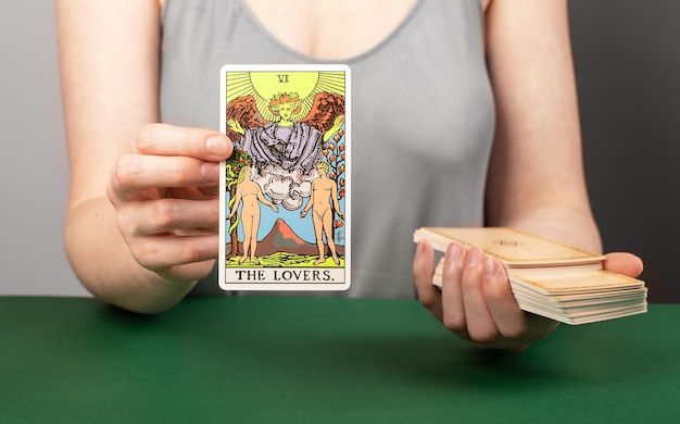 Lodz, Polonia, 15 de abril de 2023 Amantes arcana tarot lectores mano sosteniendo mostrando taro card durante la adivinación