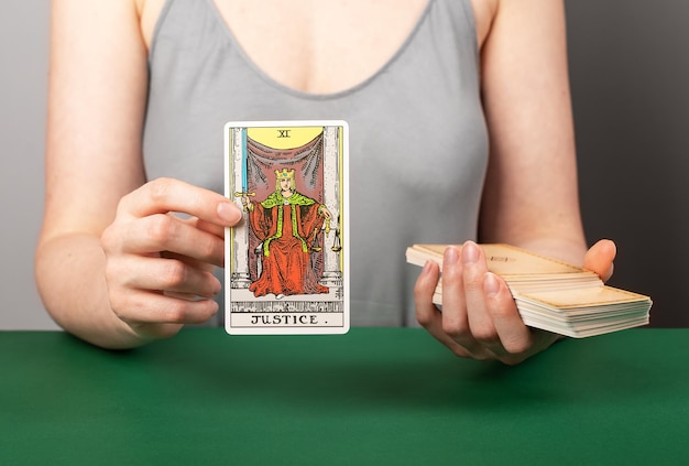 Lodz Polonia 15 de abril de 2023 Justicia arcana mano sosteniendo mostrando la carta del tarot durante la adivinación