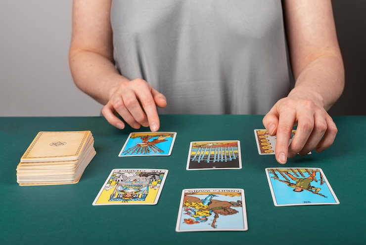 Foto lodz, polonia, 25 de abril de 2023, lector de tarot, adivino, difundiendo cartas de juego esotéricas para la adivinación
