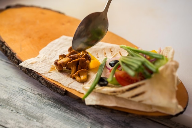 Löffel berührt gekochte Pilze. Fladenbrot mit Gemüse. Leckere gegrillte Pfifferlinge. Wie man diätetische Gerichte kocht.