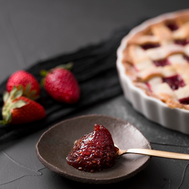 Löffel mit Erdbeermarmelade und verschwommenem Kuchen