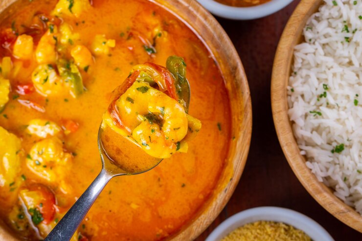 Foto löffel mit garnelen und moqueca der fisch ein traditionelles gericht der brasilianischen küche draufsicht