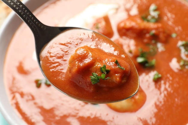 Foto löffel mit leckerem butterhuhn über schüssel mahlzeit nahaufnahme traditionelles gericht aus murgh makhani