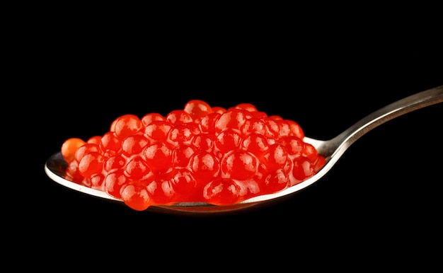 Löffel mit roter Kaviar-Nahaufnahme auf einem schwarzen