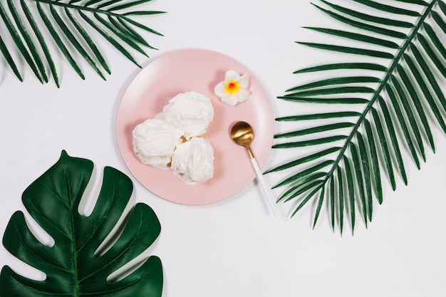 Foto löffel nahe eiscreme auf platte zwischen anlagen