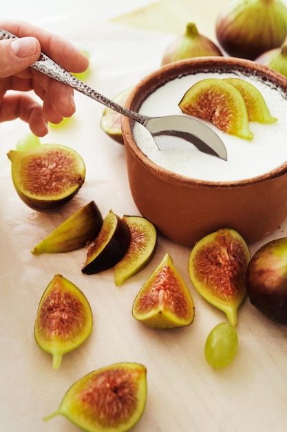 Foto löffel und köstlicher griechischer naturjoghurt in tonschale mit feigen