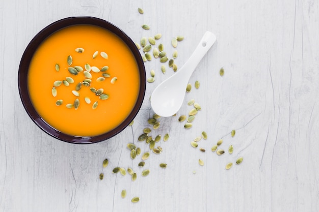 Löffel und Samen nähern sich Kürbissuppe