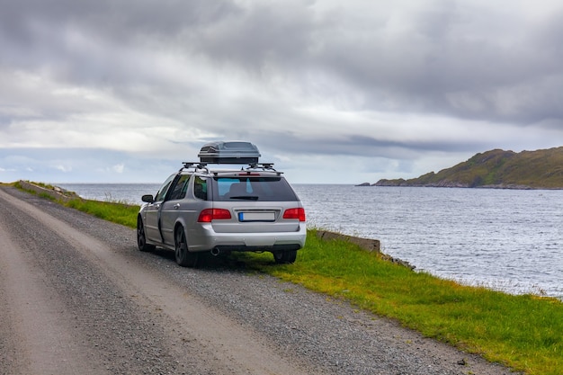 Lofoten, Noruega - 20 de junho de 2017: Um carro cinza estacionado na costa de um fiorde norueguês