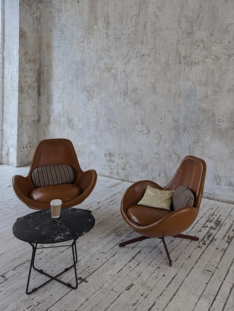 Loft-Büro-Hintergrund mit braunen Lederstühlen und einem Couchtisch
