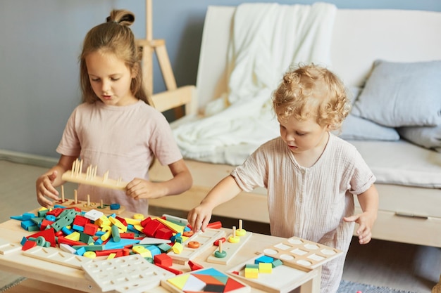 Logische Fähigkeiten von Vorschulkindern, Montessori-Lehrmethode, Holzbaukasten, Grundschulbildungszentrum, niedliche kleine Mädchen, die zu Hause mit Lernspielzeug spielen