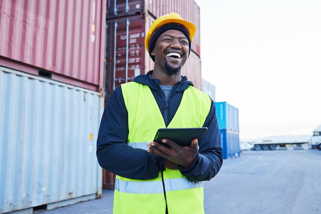 Logistik-Tablet und schwarzer Mann planen den Versand von Containern mit Technologievorrat in einem Hafen Glücklicher afrikanischer Vertriebsarbeiter, der an der Inspektion von Fracht und Fracht in einem Lager im Freien arbeitet