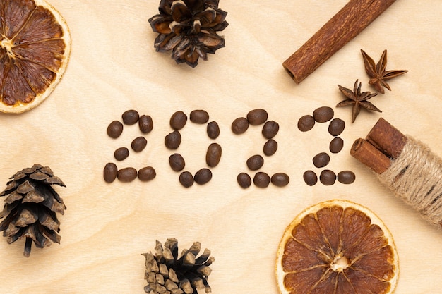 Foto logo 2022 de granos de café y especias sobre un fondo de madera marrón. feliz año nuevo 2022