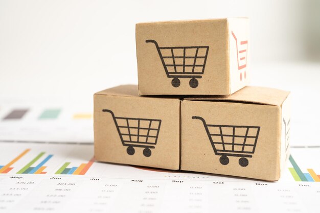 Logotipo del carrito de compras en la caja en el fondo del gráfico Cuenta bancaria Inversión Investigación analítica datos economía comercio Importación de negocios exportación transporte concepto de empresa en línea