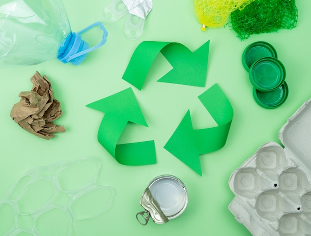 Logotipo de reciclagem verde com objetos para reciclar.