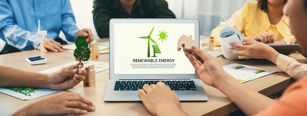 El logotipo de la energía renovable se muestra en una computadora portátil de negocio verde mientras el equipo de negocios representa el diseño verde al cliente ESG medio ambiente gobierno social y concepto conservador ecológico Closeup Delineation