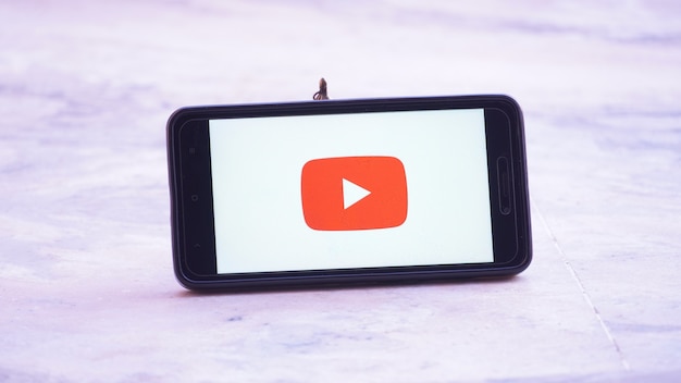 Logotipo de la pantalla de presentación de Youtube en móvil y móvil en mano