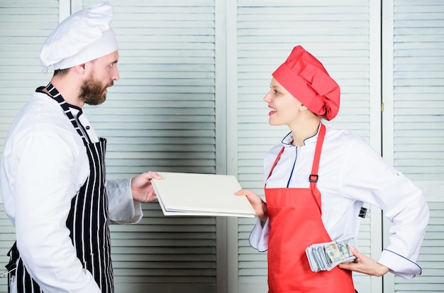 Lohn zahlen Weibliche Buchhalterin mit Kontobericht Geldlohn zahlen Restaurant-Bilanzbuch Meisterkoch und Helfer, der Kontobuch und Bargeld hält Kochhelfer, der dem Küchenchef Kocharbeitsblätter gibt