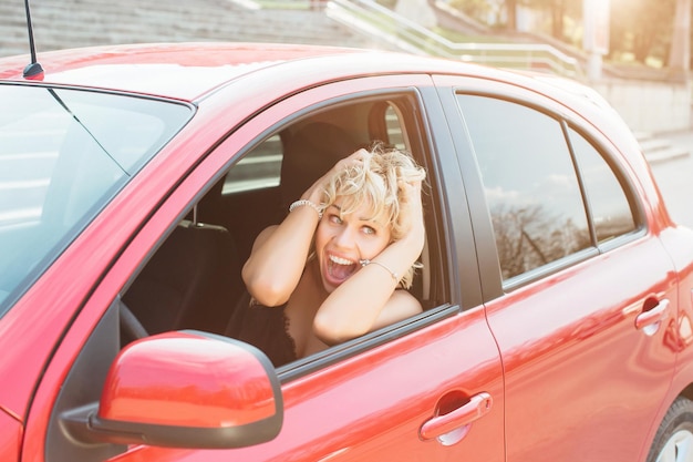 Loira atraente em um carro mostrando as chaves