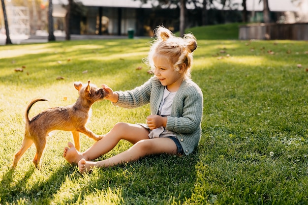 Loira brincando com um cachorrinho ao ar livre