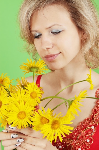 Loira com as flores amarelas sobre fundo verde