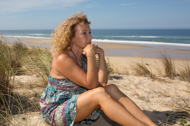 Loira e grave mulher madura na praia