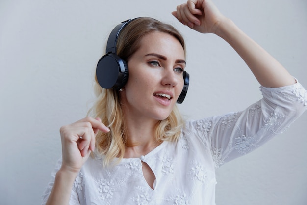 Loira linda com fones de ouvido. Ela gosta de ouvir música, cantar e se divertir.