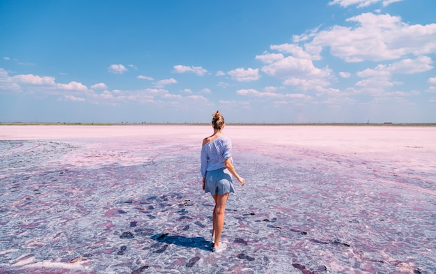 Loira linda em um lago salgado rosa no verão