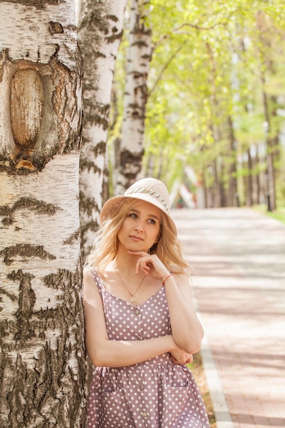 Loira linda em um vestido de verão e um chapéu