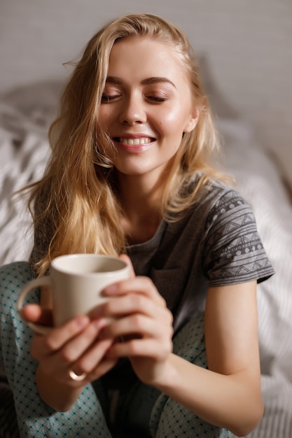 Loira segura uma xícara de café da manhã