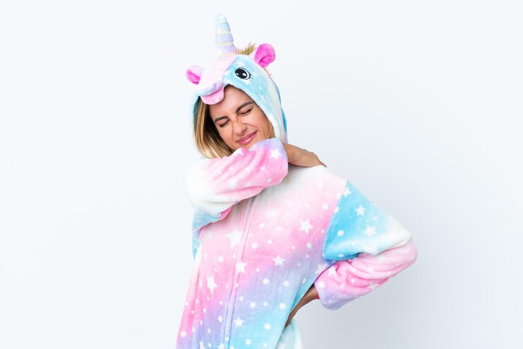 Foto loira uruguaia vestindo um pijama de unicórnio isolado no fundo branco sofrendo de dor no ombro por ter feito um esforço