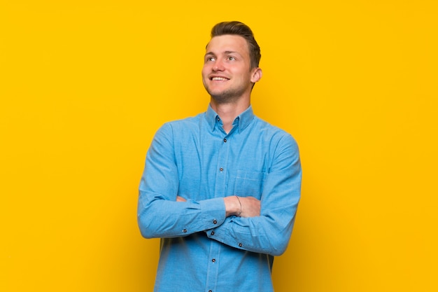 Loiro, homem, sobre, isolado, parede amarela, olhar, sorrindo