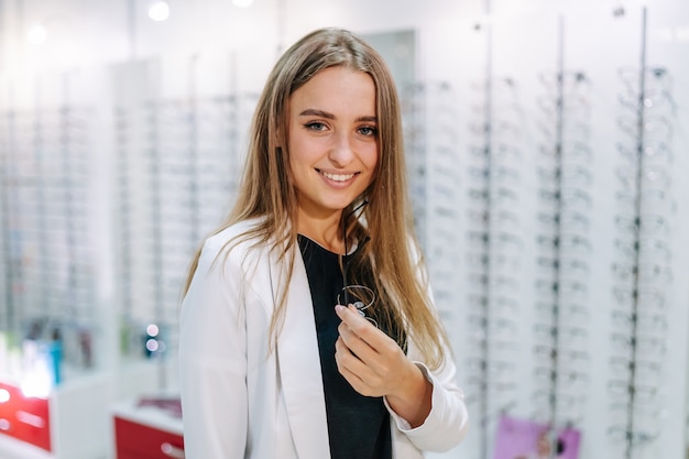 Loja de óculos. mulher com óculos de sol. escolhendo óculos. cliente em ótica. foco seletivo. fique com óculos. grande variedade na loja.